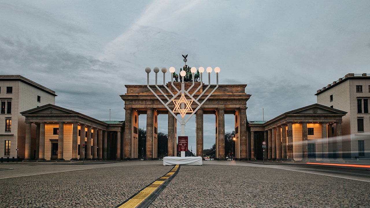 Beleuchtetes Menorah-Symbol vor dem Brandenburger Tor in Berlin.