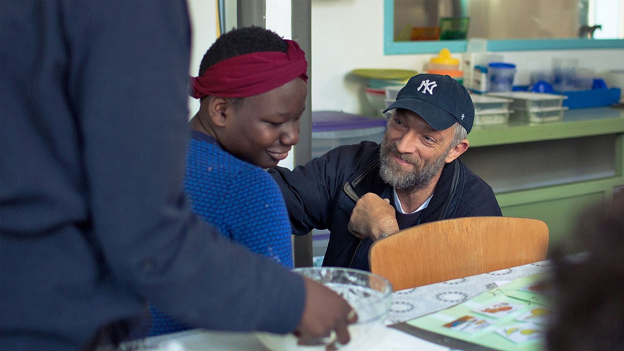 Vincent Castel im Gespräch mit einer schwarzen Frau im Film „Alles außer gewöhnlich“