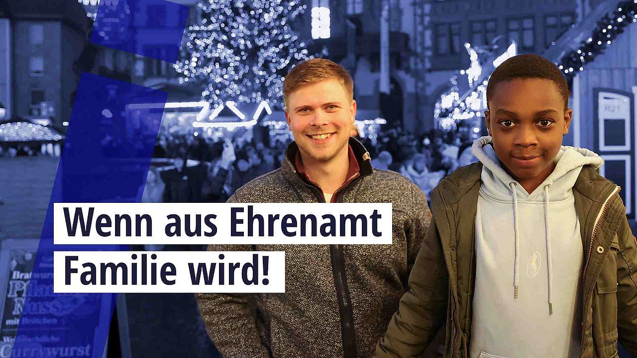 Richmond und Matthias stehen auf dem Frankfurter Weihnachtsmarkt. Darüber der Text: "Wenn aus Ehrenamt Familie wird." 