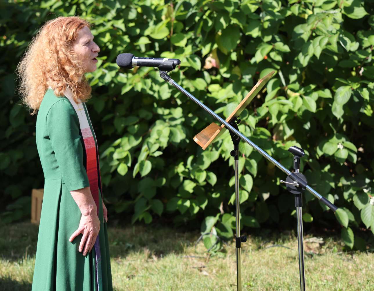 Teile des Gottesdienstes hält Brigitte Buchsein auch ohne Lesegerät. Hier steht sie Outdoor vor einem Mikrofon