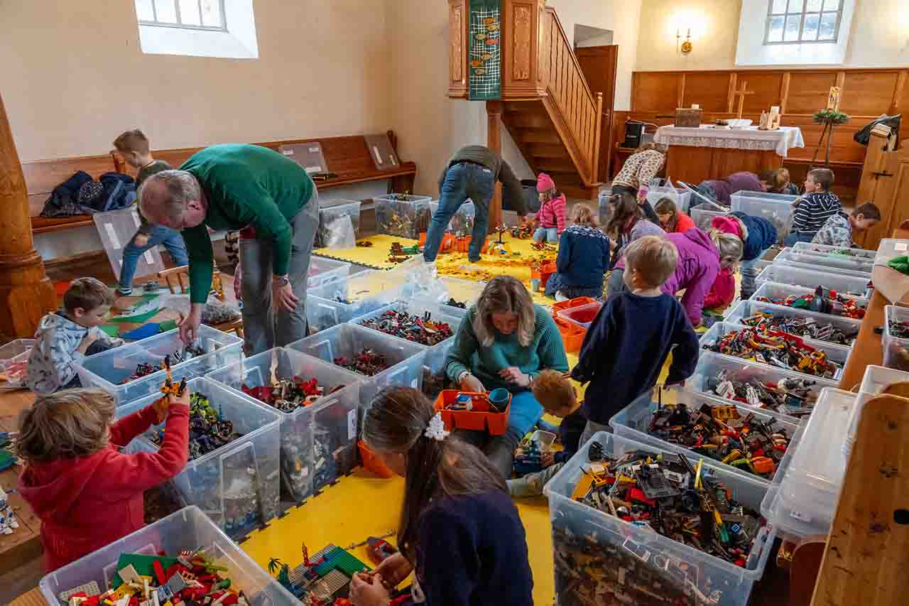 Kinder und Eltern spielen mit Lego in der Kirche