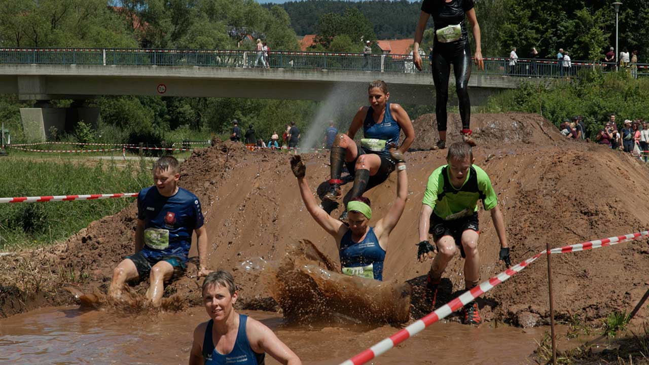 Die Teilnehmenden müssen durch die Schlammgrube