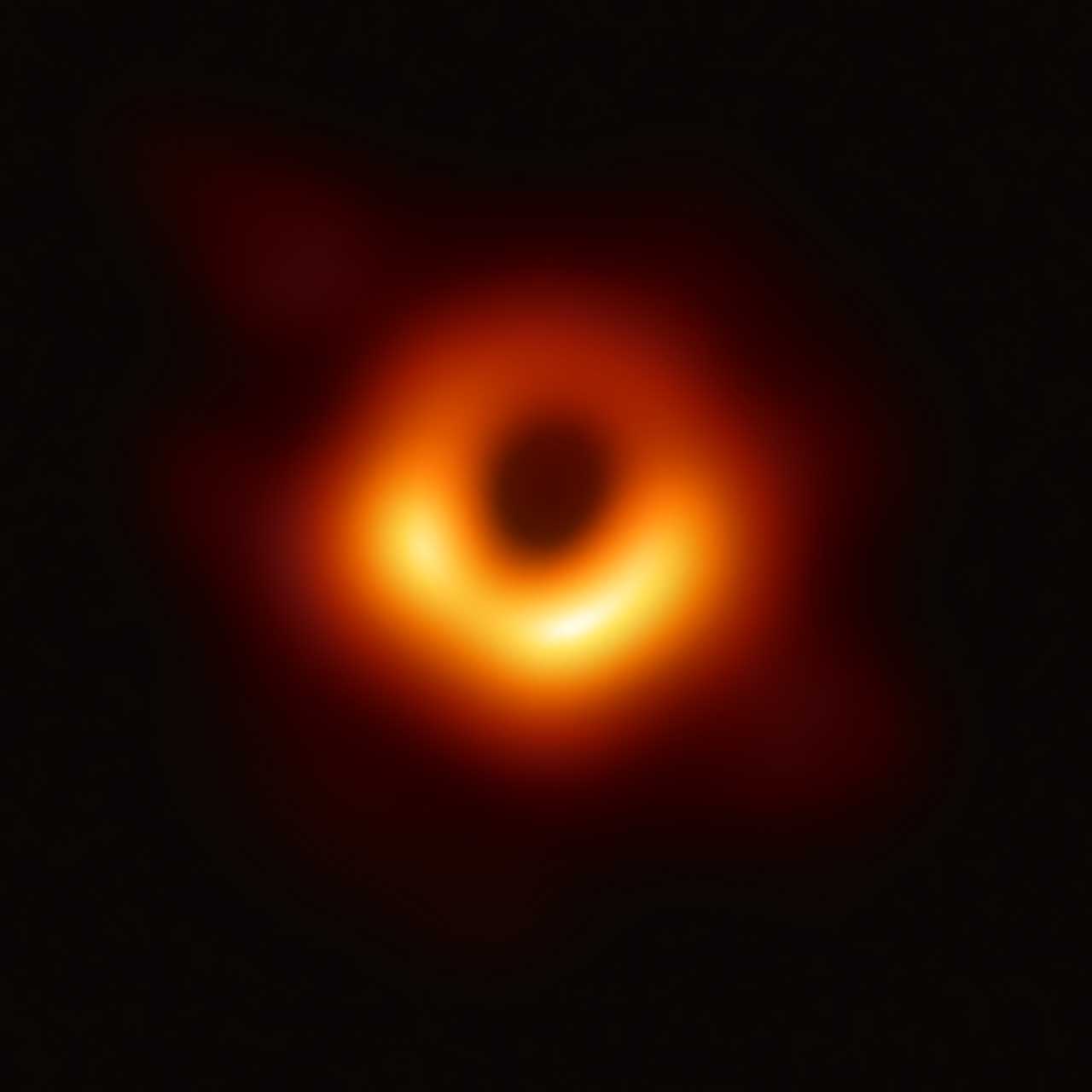 Aus Radioaufnahmen des Event Horizon Telescope berechnete Darstellung, die das supermassereiche Schwarze Loch der Galaxie M87 zeigt. Die schwarze Scheibe in der Bildmitte ist etwa 2,5-mal so groß wie der Ereignishorizont (Schwarzschild-Durchmesser ca. 38·1012 m) des supermassereichen Schwarzen Lochs im Zentrum.